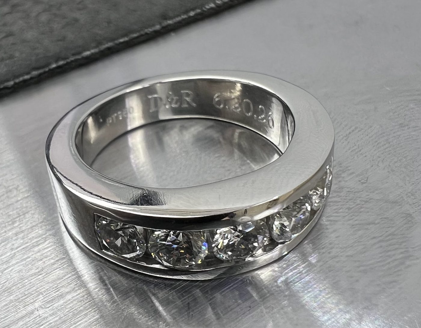 Wide silver band ring with an engraved decorative pattern