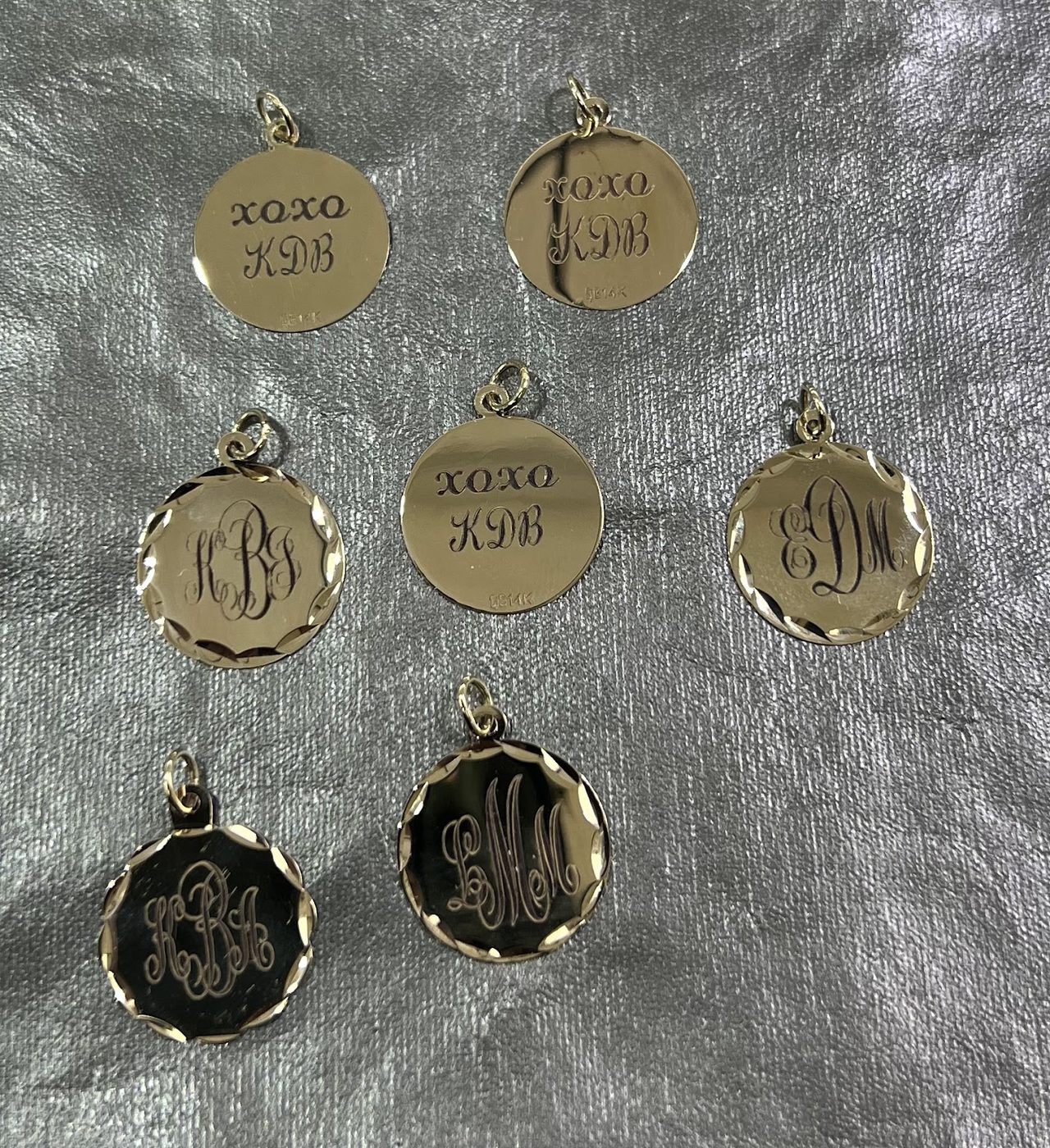 A set of gold charms engraved with names, dates and monograms