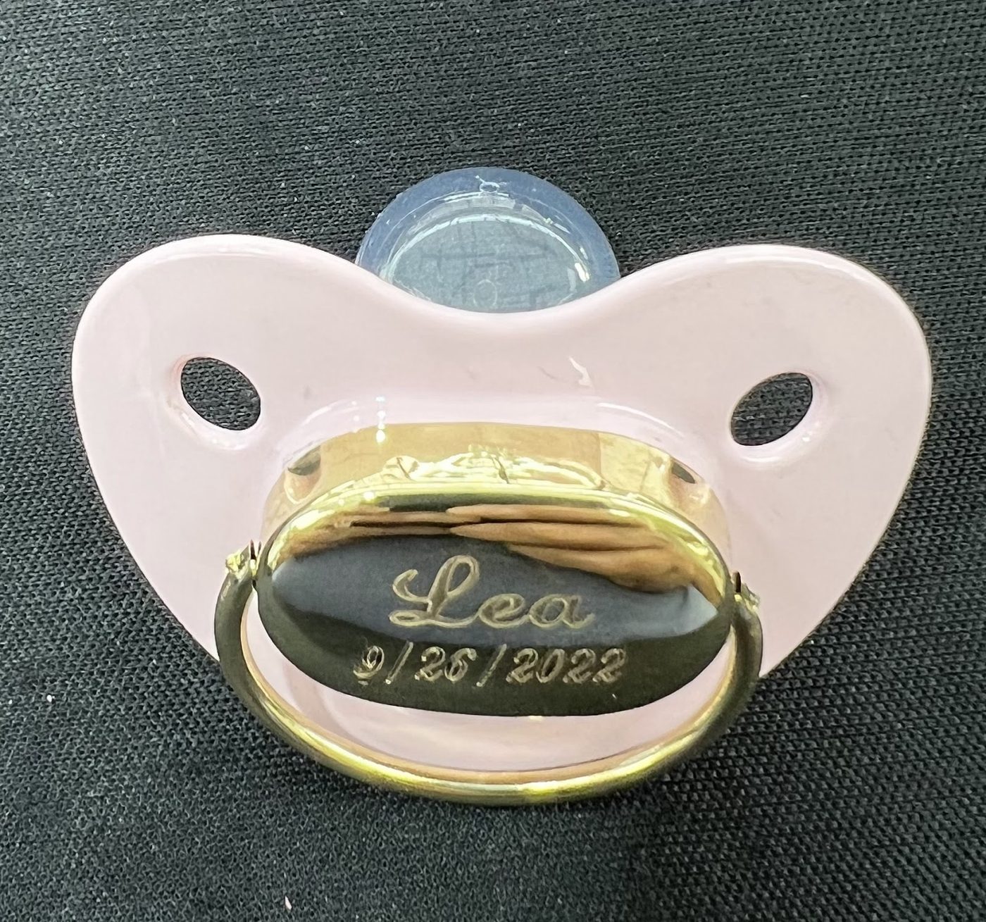 Baby pacifier with a gold plate engraved with a name and date