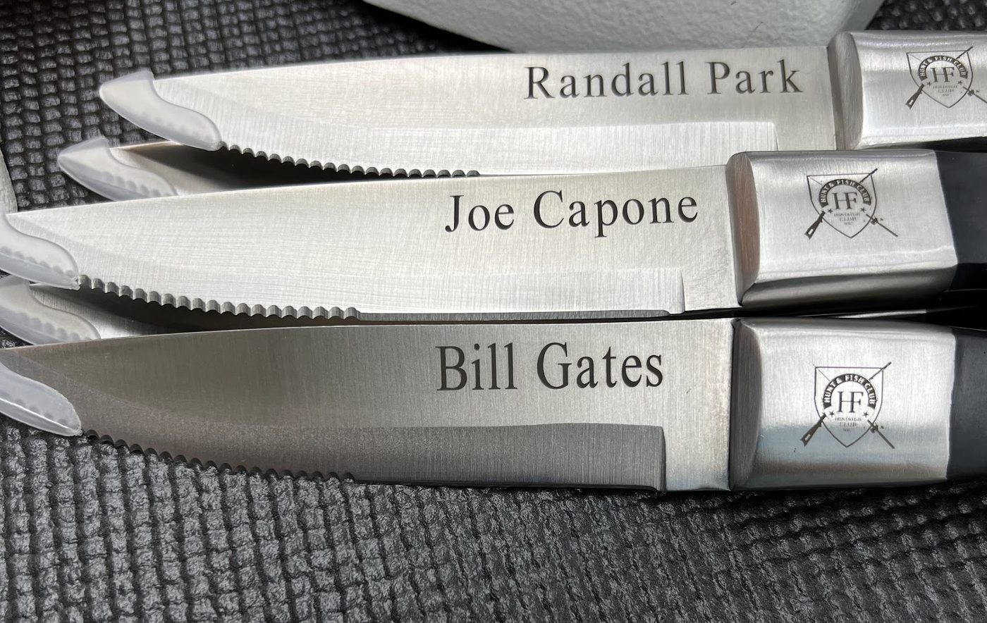 A set of steak knives each engraved with a different guest name