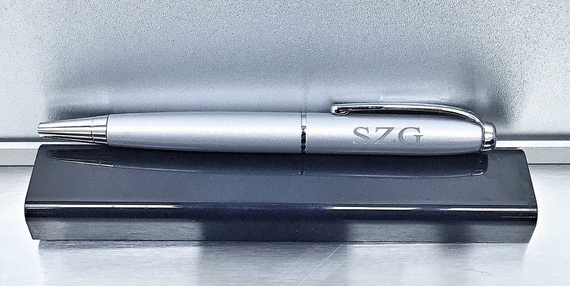 Slim silver pen engraved along the barrel