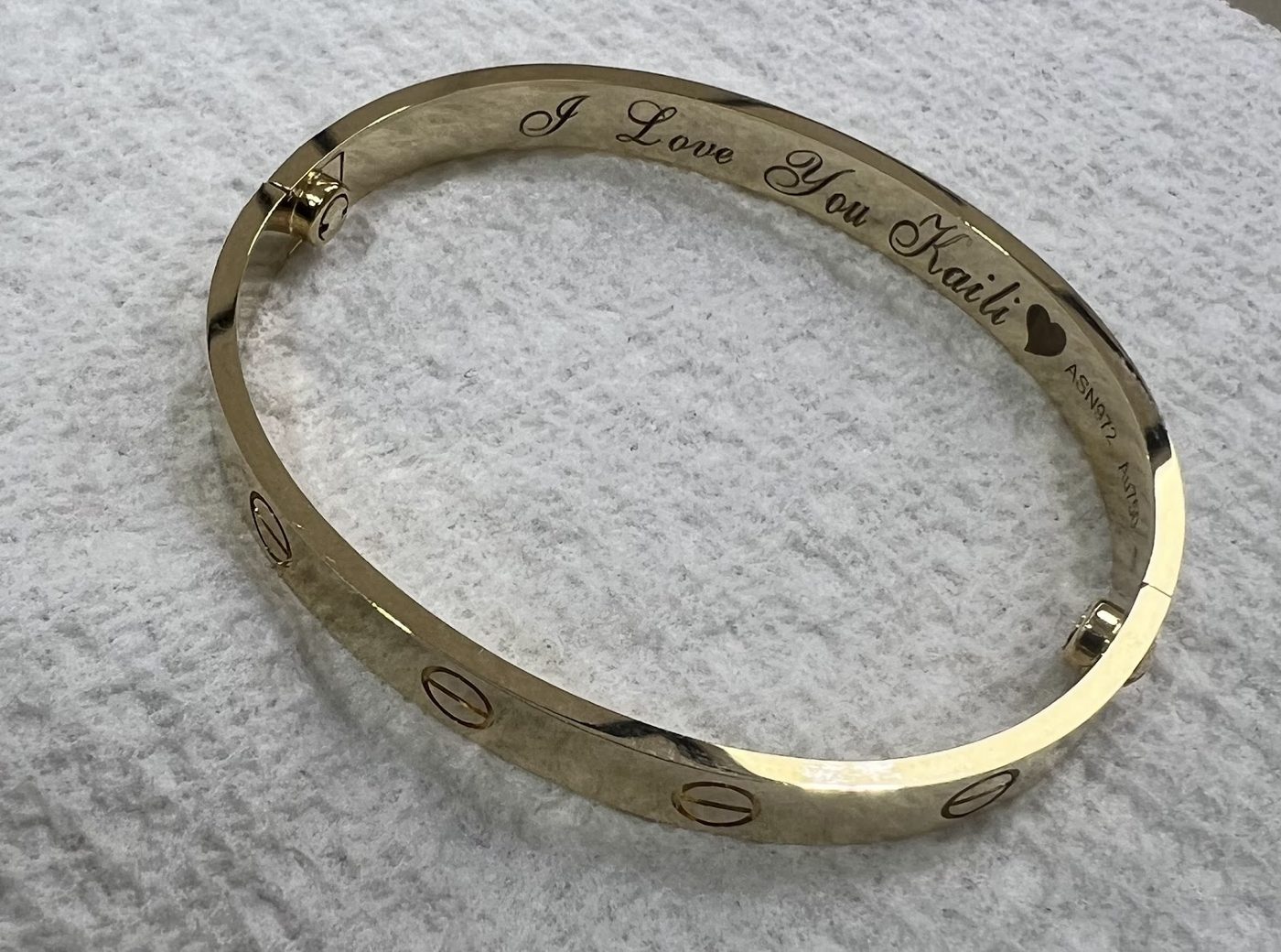 Gold bangle bracelet with a fine engraved inscription along the inside
