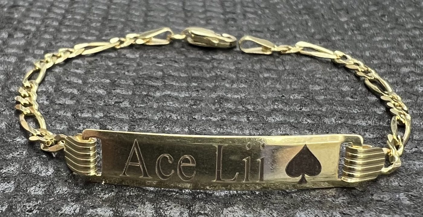 Gold identity bracelet engraved with a name and playing card symbols