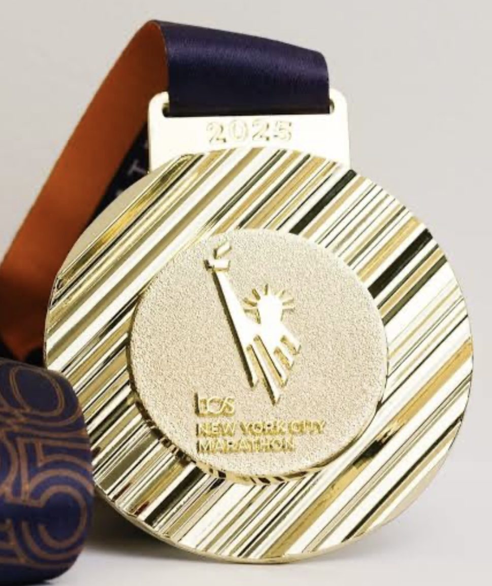 Gold 2025 TCS New York City Marathon finisher medal engraved with a Statue of Liberty motif