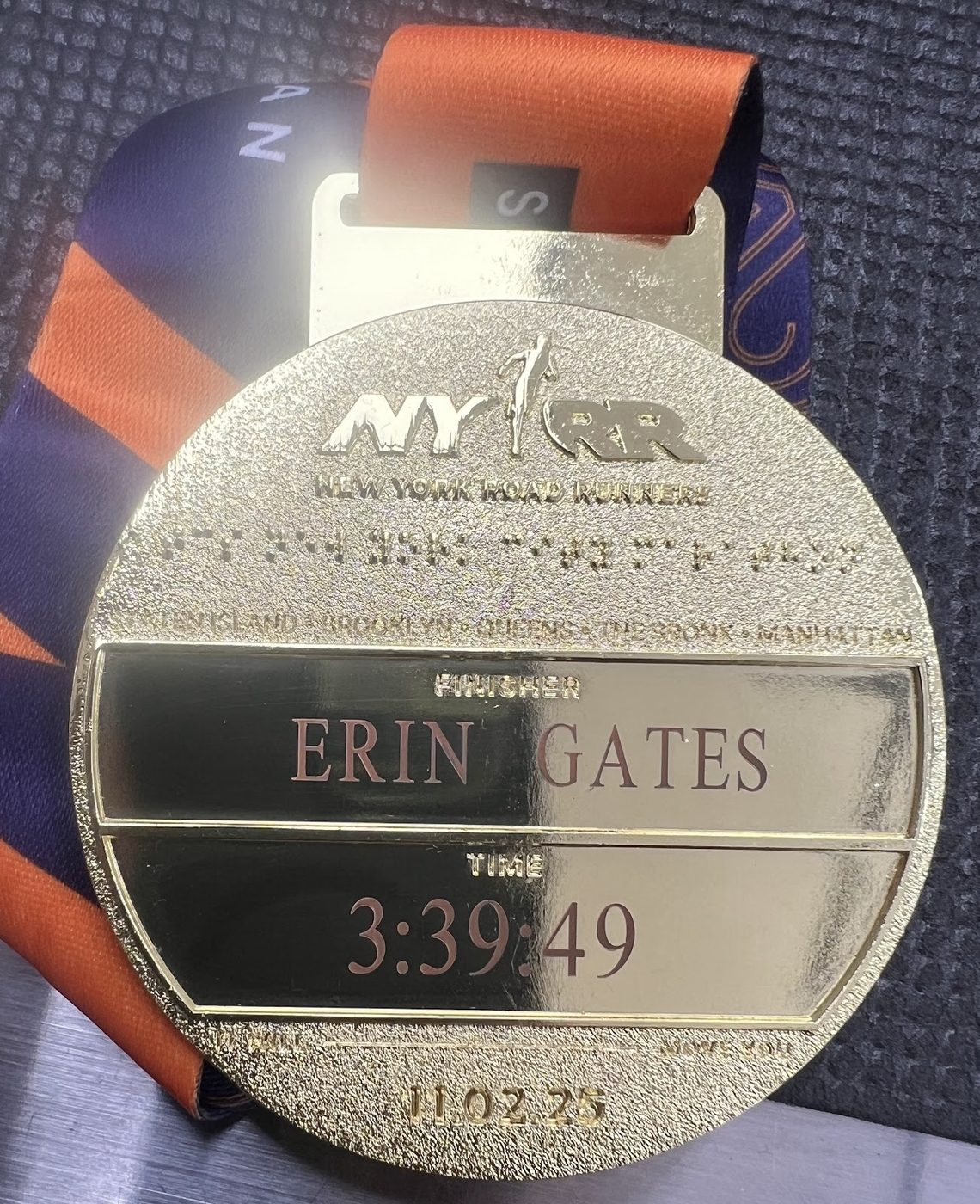 New York City Marathon medal engraved with a runner name and finishing time