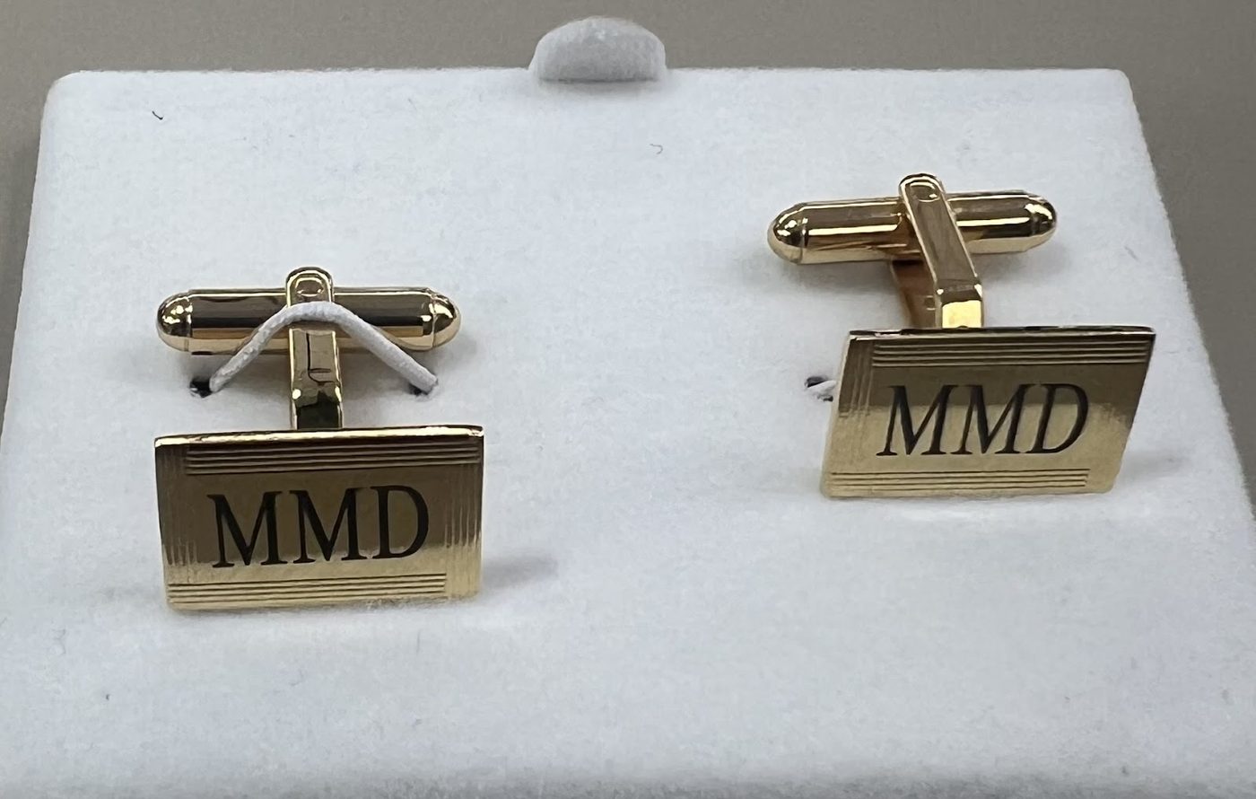Pair of gold cufflinks engraved with a three letter monogram