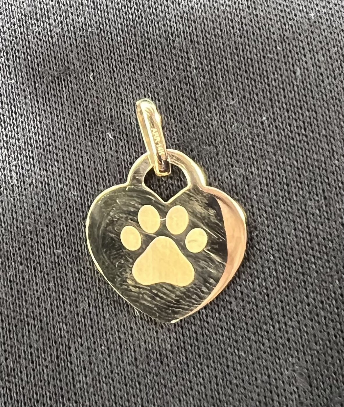Gold heart pendant engraved with a paw print