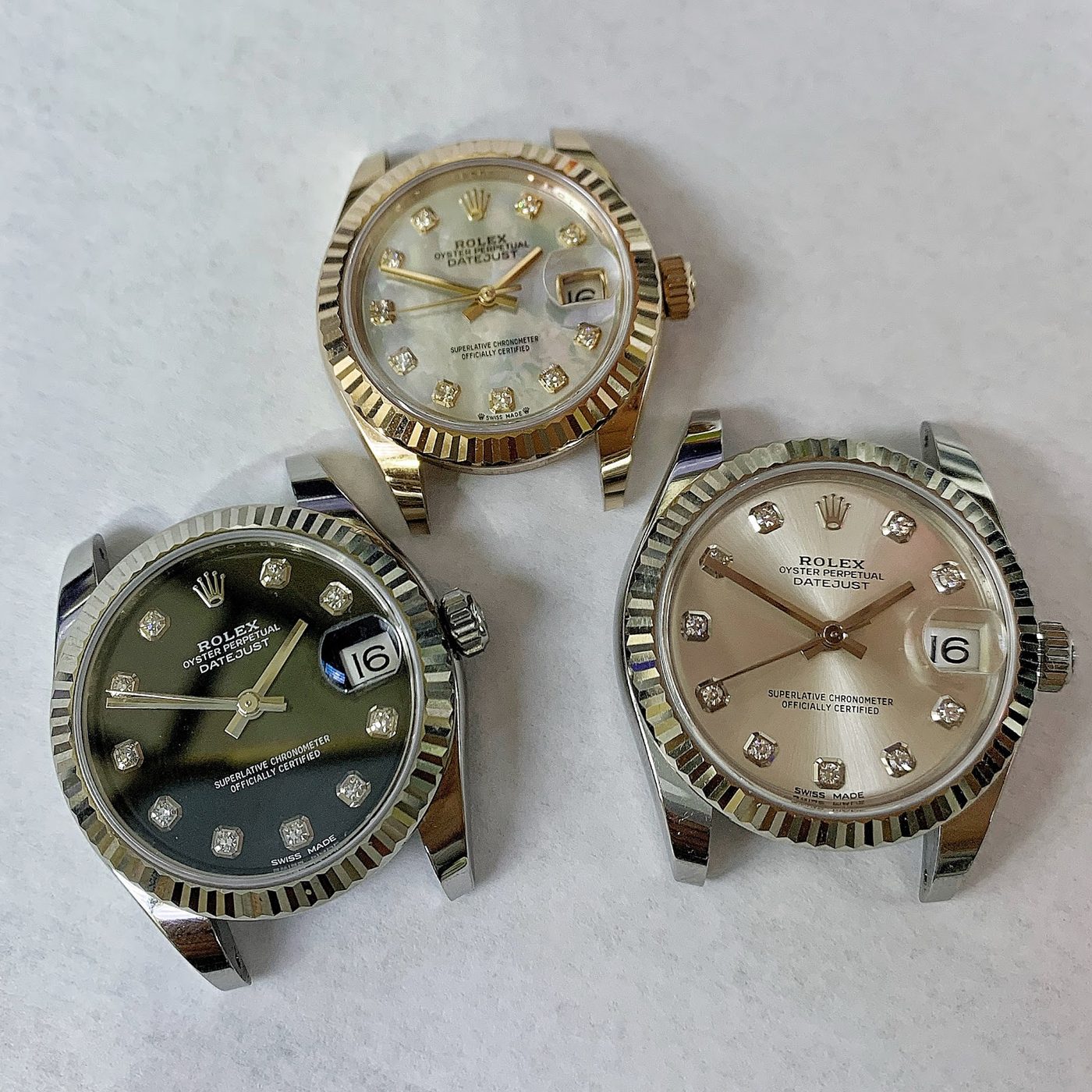 Three gold and steel Rolex watches photographed together