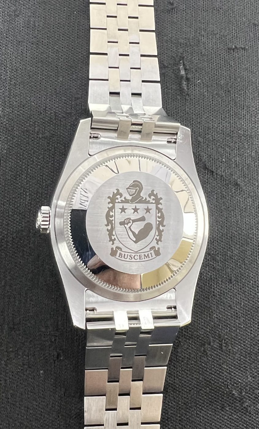 Steel Rolex Datejust with an ornate engraved bezel and jubilee bracelet