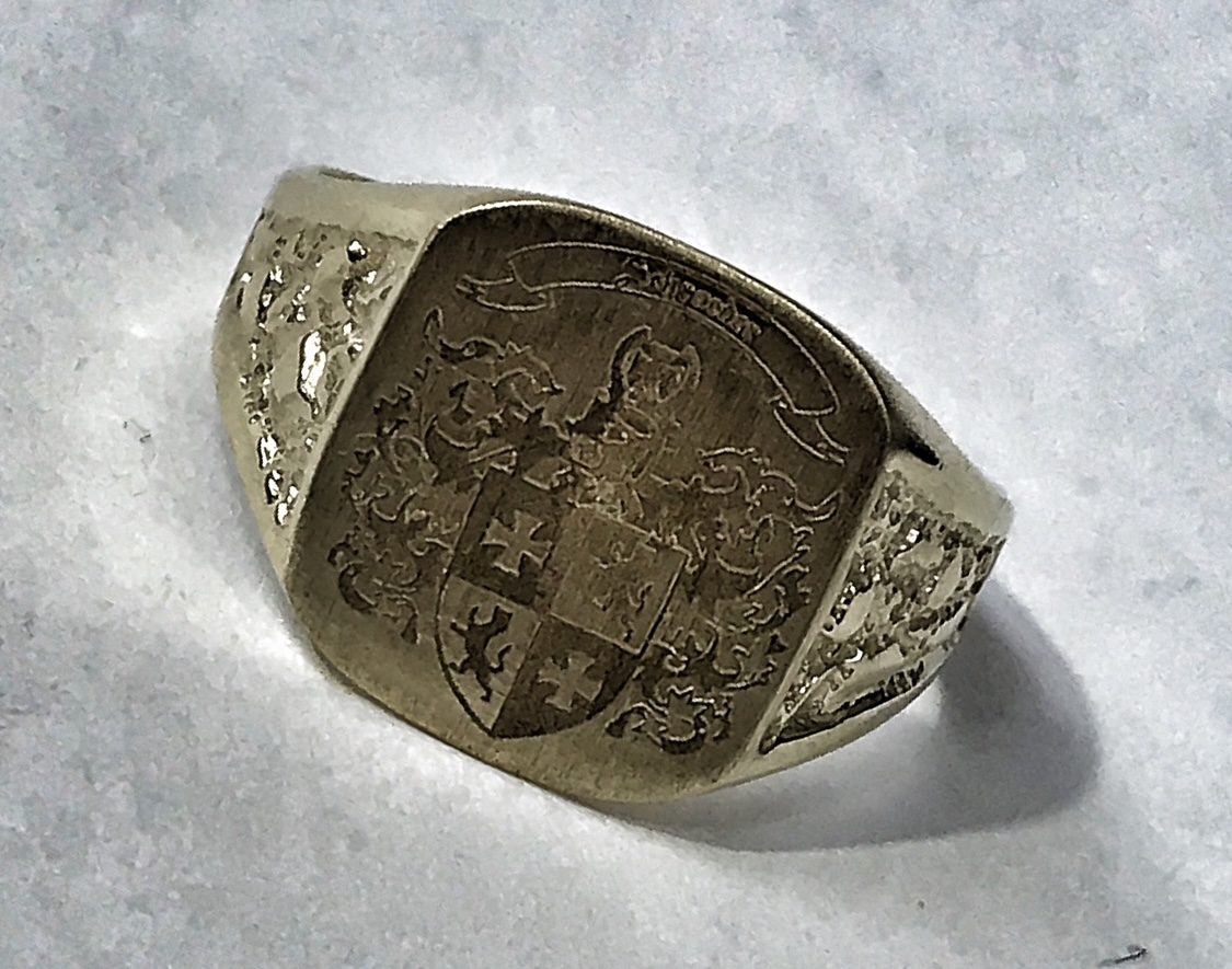 Gold signet ring with an intricately engraved crest