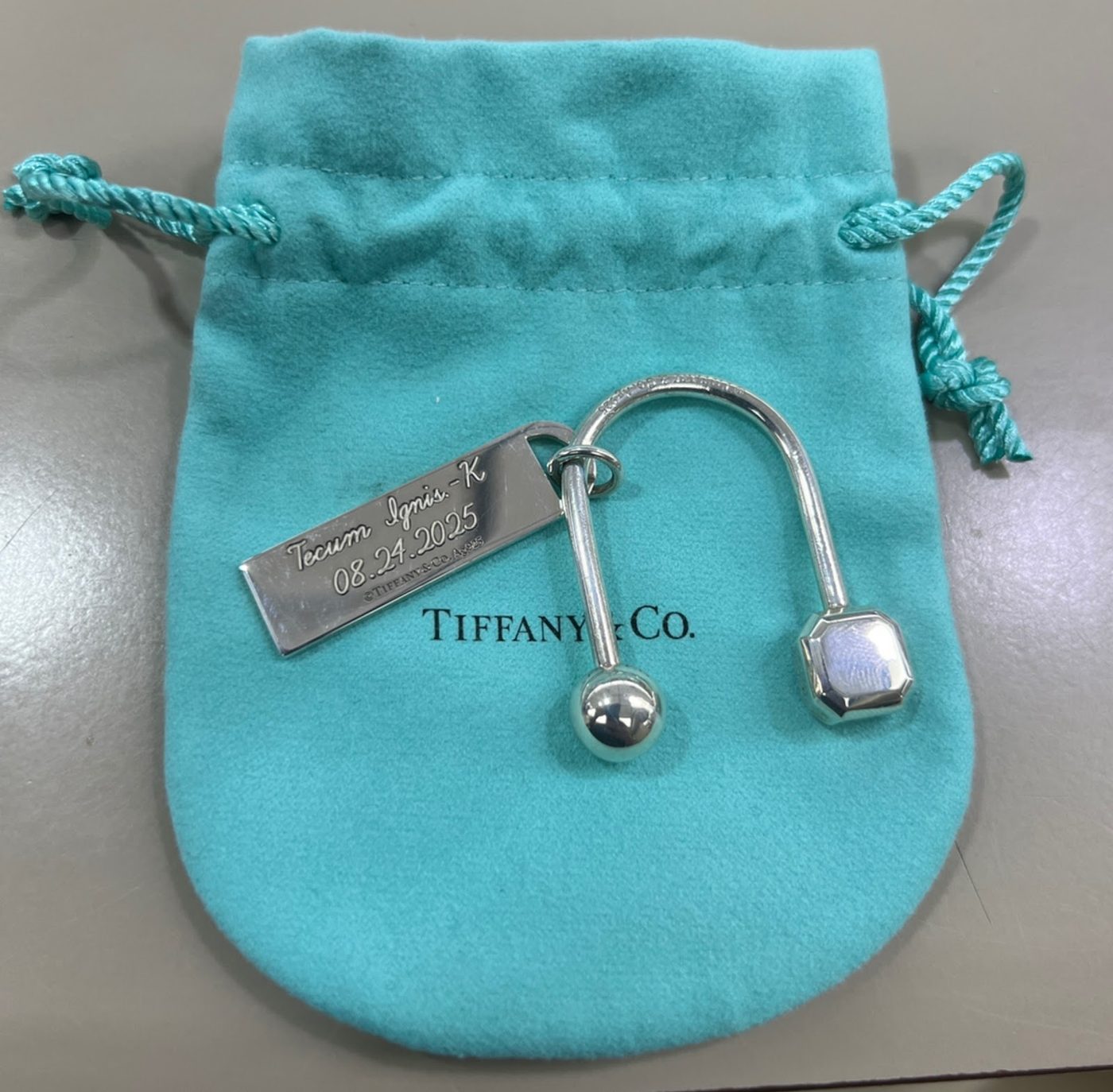 Engraved Tiffany and Company keyring beside its blue pouch