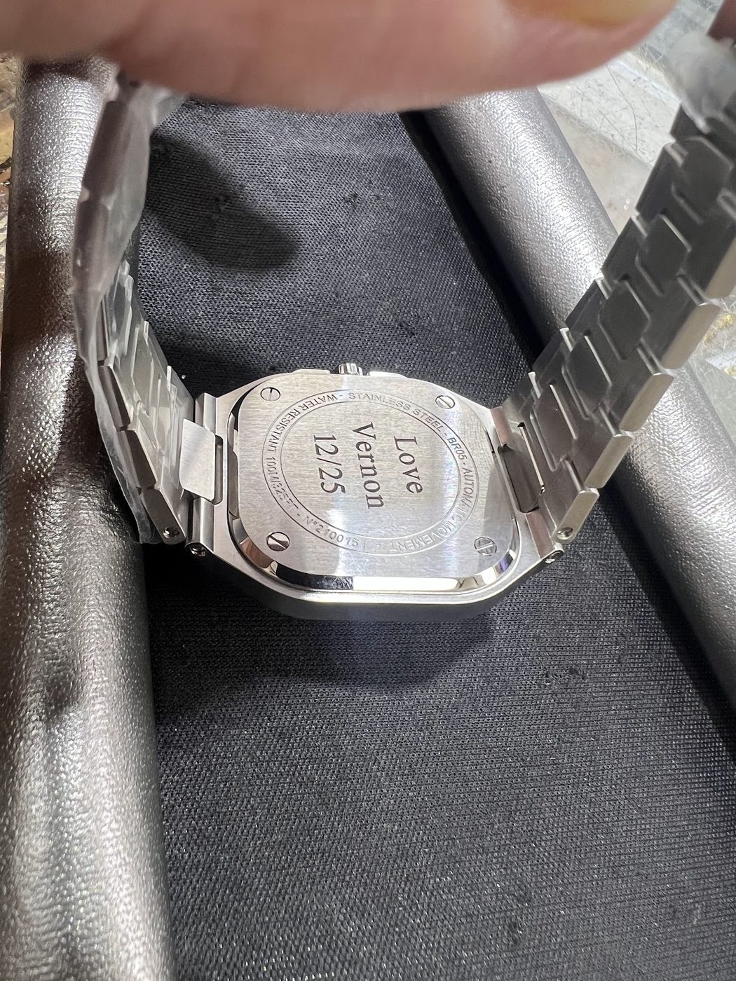 Inside of a steel watch bracelet clasp engraved with a personal message