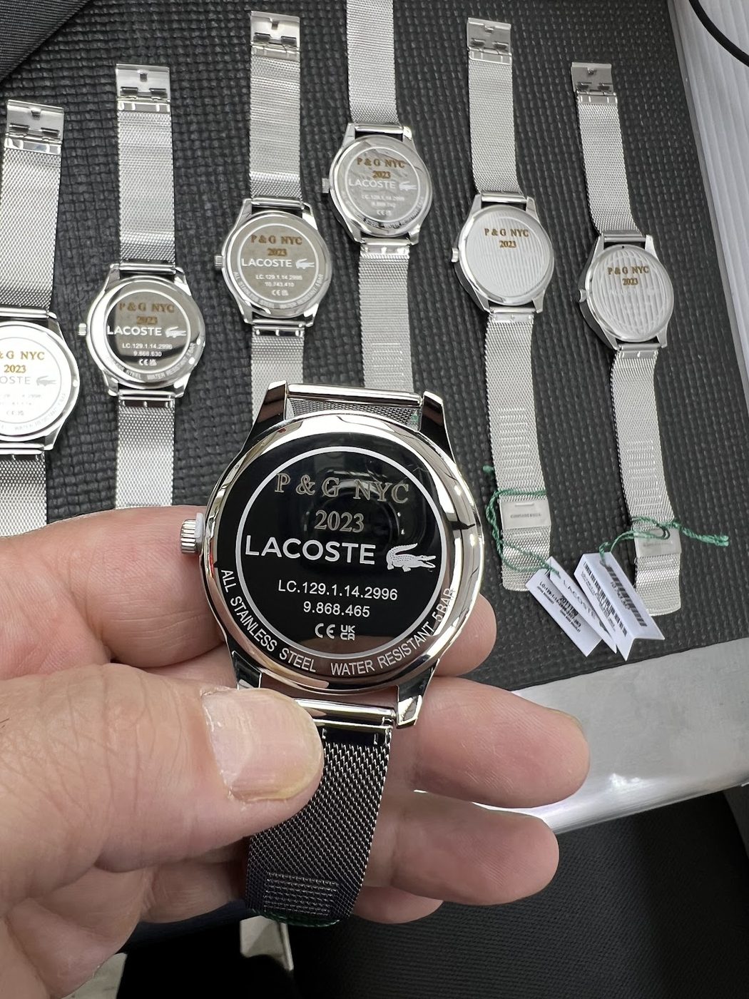 A tray of wristwatches lined up ready for engraving work