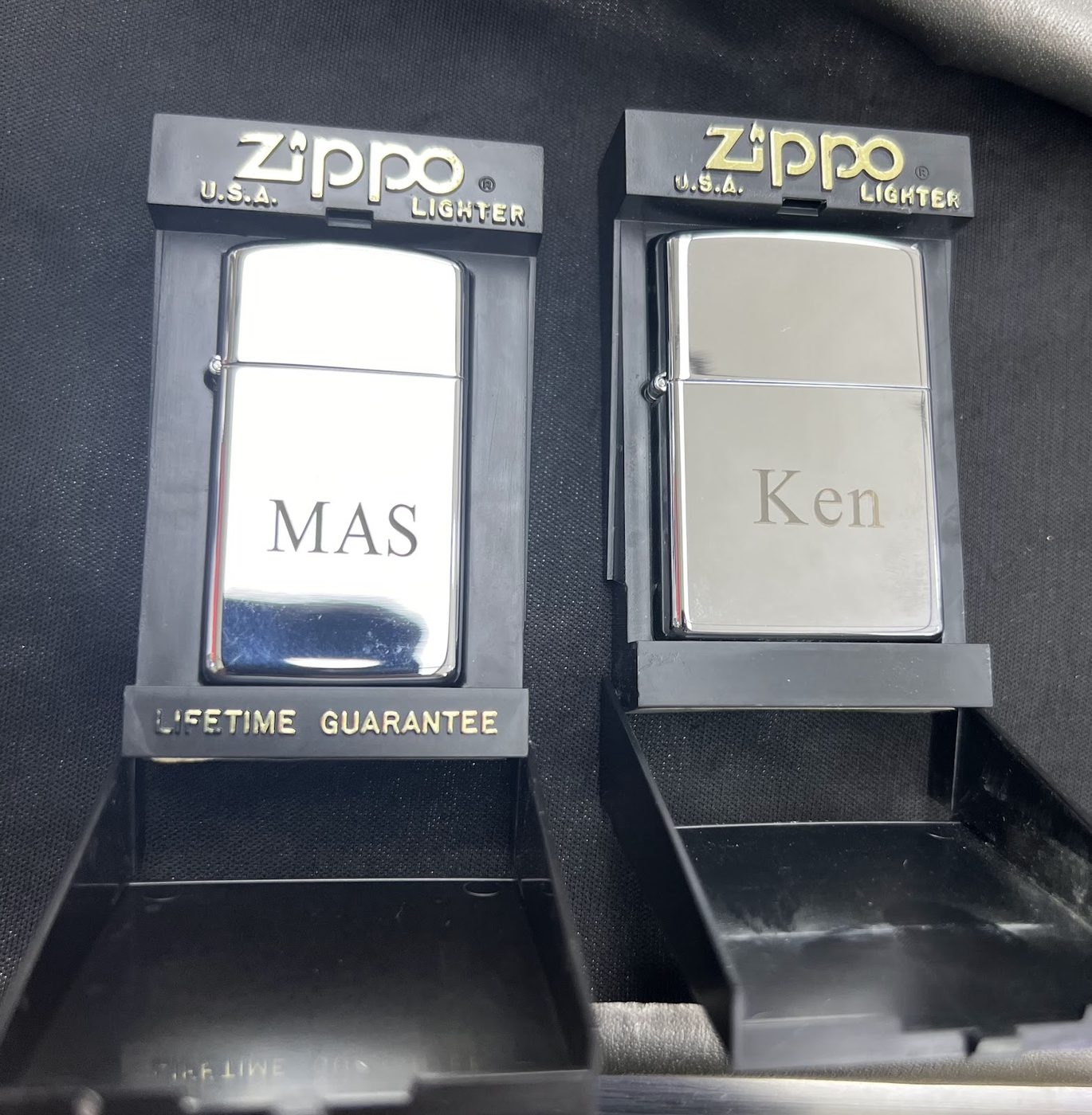 Two chrome Zippo lighters engraved with names